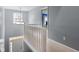 Hallway features a staircase, railing, light fixture and view down to the front door at 3322 Paisley Pointe, Whitestown, IN 46075