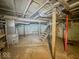 Unfinished basement showing furnace, utility pipes and wooden stairs at 3455 Hillside Ave, Indianapolis, IN 46218