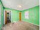 Green bedroom with two windows and orange doors, renovation is required at 3455 Hillside Ave, Indianapolis, IN 46218