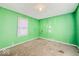 Empty green bedroom with window and electrical outlets, and a worn carpet at 3455 Hillside Ave, Indianapolis, IN 46218