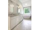 Main bathroom features double sinks, granite countertop, modern white cabinets and a soaking tub by a window at 3604 Maple Ridge Dr, Columbus, IN 47201