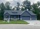 Charming single-story home featuring a three-car garage, stone accents, and a well-manicured lawn at 3604 Maple Ridge Dr, Columbus, IN 47201