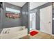Modern bathroom with a soaking tub, glass-enclosed shower, and stylish gray walls at 3844 Kilburn Ct, Indianapolis, IN 46228