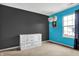 Bright bedroom featuring neutral carpet, large window and a modern gray and blue color scheme at 3844 Kilburn Ct, Indianapolis, IN 46228