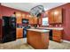 Well-equipped kitchen with modern black appliances, wood cabinets, and functional island at 3844 Kilburn Ct, Indianapolis, IN 46228