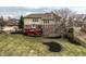 A beautiful backyard with a red wood deck on a home with brick and siding, a large yard, and mature trees at 3880 Heathfield Ct, Zionsville, IN 46077