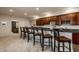 Finished basement bar with seating and custom cabinets provides seamless entertaining and opens to den at 3880 Heathfield Ct, Zionsville, IN 46077