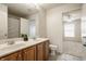 Bathroom featuring dual sinks, wood cabinets, shower with curtain and views to bedroom at 3880 Heathfield Ct, Zionsville, IN 46077