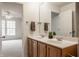 Bathroom featuring dual sinks, wood cabinets, and views to the bedroom at 3880 Heathfield Ct, Zionsville, IN 46077