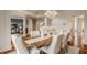 Elegant dining room featuring a chandelier, a rustic wood table, and upholstered chairs with nailhead trim at 3880 Heathfield Ct, Zionsville, IN 46077