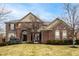Charming two-story brick home featuring manicured landscaping and an inviting arched entryway at 3880 Heathfield Ct, Zionsville, IN 46077