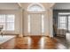 Bright foyer with hardwood floors, white trim, and a view of the front door and sidelight windows at 3880 Heathfield Ct, Zionsville, IN 46077