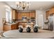 Charming kitchen view from the dining area featuring wood cabinets, updated appliances, and a cozy breakfast bar at 3880 Heathfield Ct, Zionsville, IN 46077