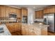 Spacious kitchen featuring wood cabinets, stainless steel appliances, and an island, creating a functional and stylish cooking space at 3880 Heathfield Ct, Zionsville, IN 46077