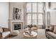 Elegant living room with a cozy fireplace, large windows, and stylish decor, ideal for comfortable living and entertaining at 3880 Heathfield Ct, Zionsville, IN 46077