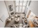 Aerial view of a well-appointed living room with fireplace, two-story windows, and modern furniture, showcasing spacious design at 3880 Heathfield Ct, Zionsville, IN 46077