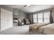 Bright main bedroom featuring a seating area, ceiling fan, neutral color scheme, and an ensuite bathroom at 3880 Heathfield Ct, Zionsville, IN 46077