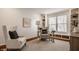Bright home office featuring built-in shelving, a glass desk, and comfortable seating at 3880 Heathfield Ct, Zionsville, IN 46077