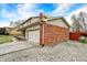 Charming two-story home with a brick facade, tan siding, two-car garage, and gravel driveway at 3968 Creekwood Dr, Greenwood, IN 46142