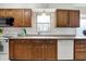 Classic eat-in kitchen features wood cabinetry, white appliances, and a window above the sink at 3968 Creekwood Dr, Greenwood, IN 46142