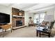 Cozy living room with a brick fireplace, white ceiling beams, and plush carpeting at 3968 Creekwood Dr, Greenwood, IN 46142