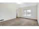 Cozy living room with plush carpeting, natural light from the large window, and neutral color palette at 3968 Creekwood Dr, Greenwood, IN 46142
