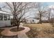 Backyard view featuring a brick-laid circular walkway, a detached garage and a sunroom addition to the main home at 4212 Broadway St, Indianapolis, IN 46205