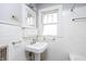 Classic white bathroom with subway tile, a pedestal sink, and a medicine cabinet at 4212 Broadway St, Indianapolis, IN 46205