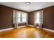 Bedroom featuring hardwood floors, large windows, and colorful floral curtains at 4212 Broadway St, Indianapolis, IN 46205