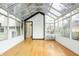 Bright sunroom featuring a glass ceiling, neutral decor, and access to the outdoors at 4212 Broadway St, Indianapolis, IN 46205