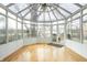 Sunroom with a glass ceiling and walls, and gleaming hardwood floors at 4212 Broadway St, Indianapolis, IN 46205