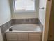 A bathtub with jets and a window, with gray tile and neutral paint at 457 Prince Dr, Greenwood, IN 46142