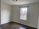 A cozy bedroom features dark wood floors, neutral walls and a window bringing in natural light at 457 Prince Dr, Greenwood, IN 46142