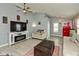 Bright living room with a ceiling fan, a stylish fireplace, wood laminate flooring, and a red front door at 4704 Whitview Ln, Indianapolis, IN 46237