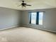 Expansive primary bedroom with plush carpeting, large window, and ceiling fan for comfort and relaxation at 476 Haywood Dr, Greenfield, IN 46140