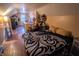 An attic bedroom with hardwood floors, black and white patterned bedding, and a storage area at 5068 W 10Th St, Indianapolis, IN 46224