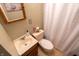 A small bathroom featuring a toilet, sink, mirror and shower at 5068 W 10Th St, Indianapolis, IN 46224