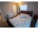 This bedroom features a wooden bed frame, neutral walls, two windows, and hardwood floors at 5068 W 10Th St, Indianapolis, IN 46224