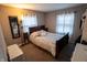 This bedroom features a wooden bed frame, neutral walls, two windows, and hardwood floors at 5068 W 10Th St, Indianapolis, IN 46224