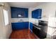 Bright kitchen features stylish blue cabinetry, stainless steel appliances, and a white backsplash at 5068 W 10Th St, Indianapolis, IN 46224