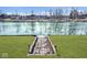 Backyard with lawn leading to the water, featuring a wooden walkway for easy access to the lake at 5519 Fall Creek Rd, Indianapolis, IN 46220