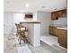 Basement bar featuring tile floors, sink, wooden bar with seating, cabinets, and wine rack at 5519 Fall Creek Rd, Indianapolis, IN 46220