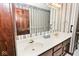 Bathroom features a double sink vanity with framed mirror, and striped wallpaper at 5519 Fall Creek Rd, Indianapolis, IN 46220