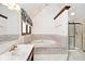 Bathroom featuring a soaking tub, tiled accents, and a large vanity at 5519 Fall Creek Rd, Indianapolis, IN 46220
