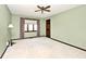 Bedroom features a large window, neutral carpet, and a classic ceiling fan at 5519 Fall Creek Rd, Indianapolis, IN 46220