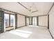 Spacious bedroom featuring tray ceilings, a ceiling fan, and multiple windows with scenic views at 5519 Fall Creek Rd, Indianapolis, IN 46220