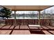 Picturesque covered deck featuring a bench and scenic view of the serene lake and surrounding landscape at 5519 Fall Creek Rd, Indianapolis, IN 46220