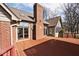 Spacious outdoor deck with brick chimney, glass sliding doors, and access to a sunroom, perfect for outdoor entertaining at 5519 Fall Creek Rd, Indianapolis, IN 46220