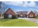Red brick home with a well-manicured lawn and mature trees, creating a serene and inviting atmosphere at 5519 Fall Creek Rd, Indianapolis, IN 46220