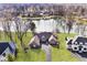 Aerial view of a waterfront home with well-manicured lawn, mature trees, and access to the water at 5519 Fall Creek Rd, Indianapolis, IN 46220